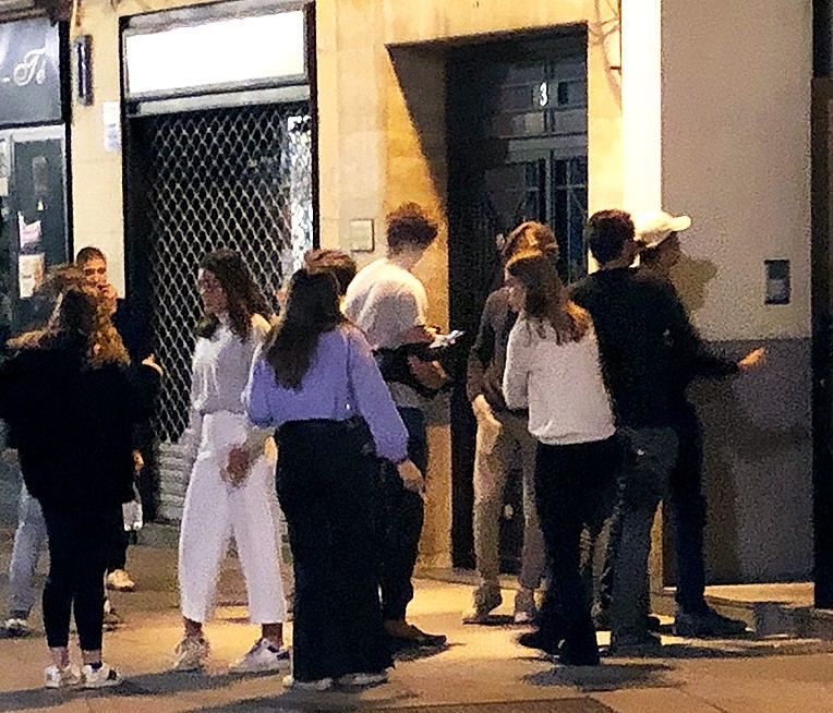 Estudiantes universitarios, en la Calle Real, a la espera de acceder a un piso donde se celebra una fiesta. 
