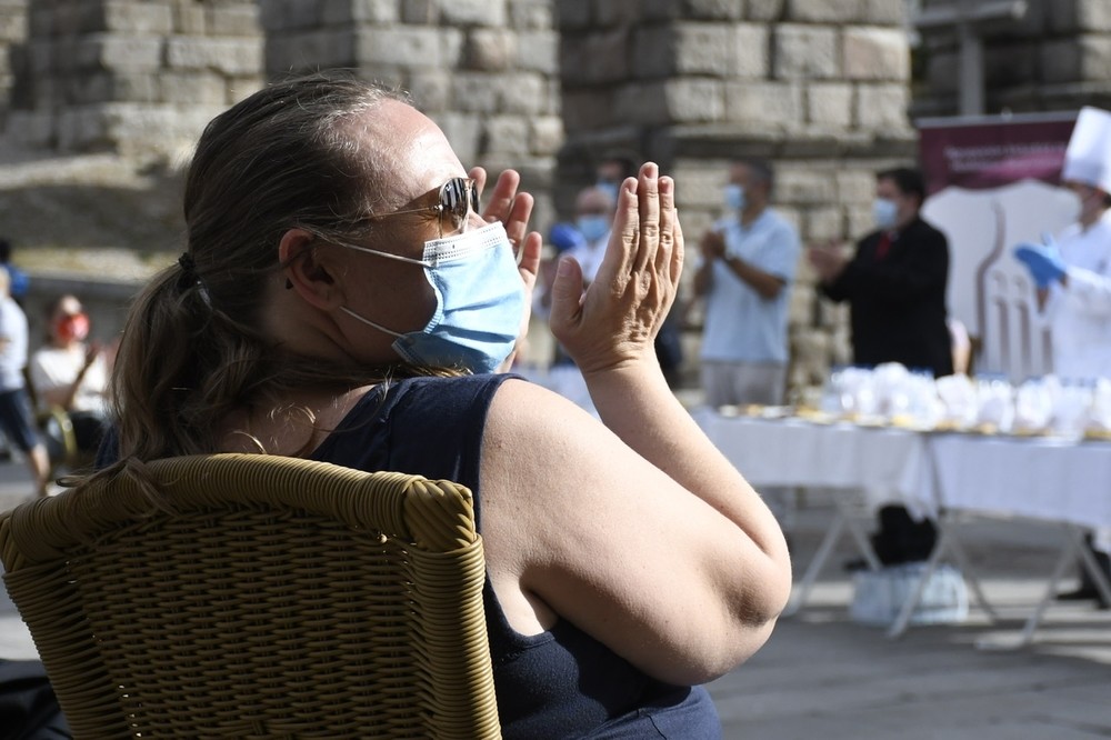 Una de las sanitarias participantes aplaude en el almuerzo que se ha celebrado después a los pies del Acueducto.