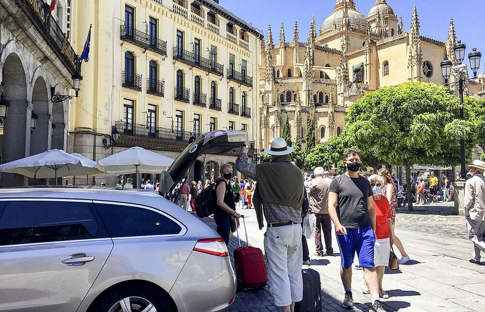 Unos turistas descargan maletas en la Plaza Mayor de Segovia.