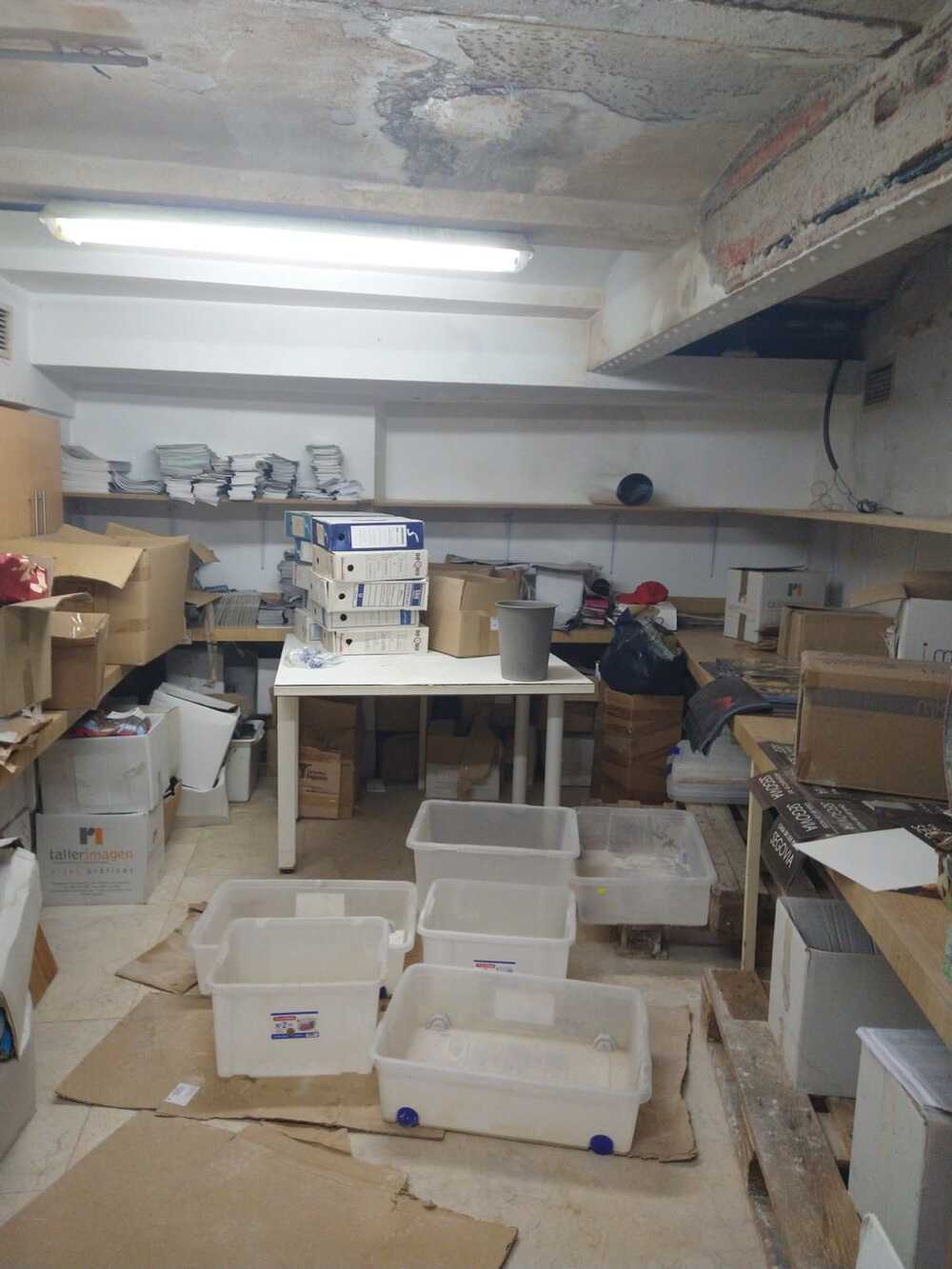 Sala de almacén de material llena de cubos para las goteras.